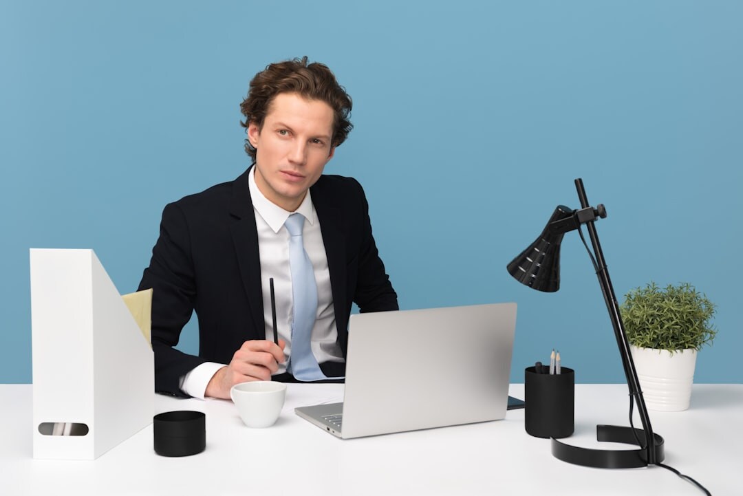 Business professional working at a desk with a laptop and documents